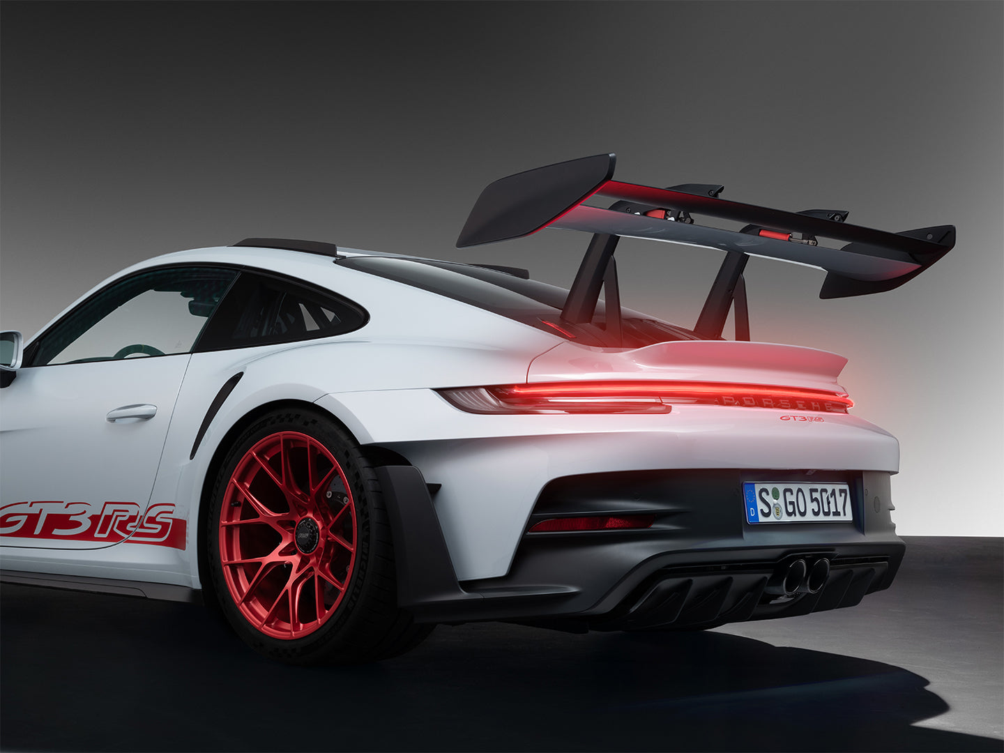 Modern living room interior mockup featuring an illuminated Porsche 911 GT3 RS supercar neon sign hung above a sofa.
